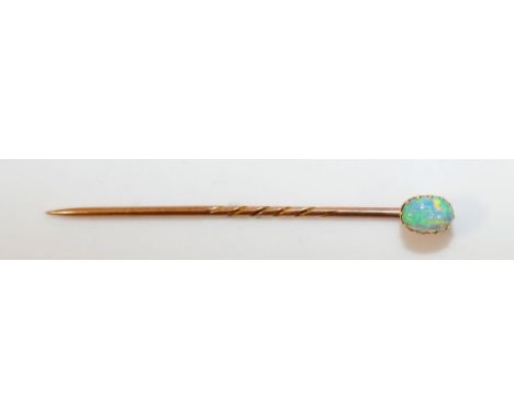 A yellow metal opal stick pin, the oval cabochon stone 4.5mm x 6.5mm x 2mm deep, in claw setting, 5.3cm long CONDITION REPORT