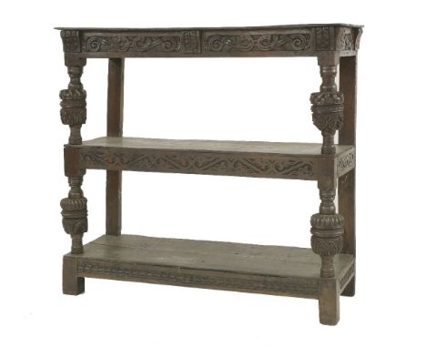 An oak buffet,early 17th century, with three tiers and carved decoration,130cm wide47cm deep124cm high