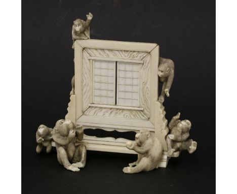 A Japanese ivory table screen,late 19th century, mounted with six monkeys, one wearing a jacket and waving, 15cm wide15cm hig