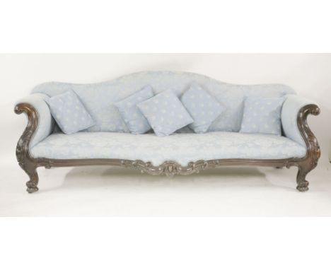 A large mahogany framed sofa,late 19th century, with an arched back and scroll arms, with crisply carved decoration,240cm wid