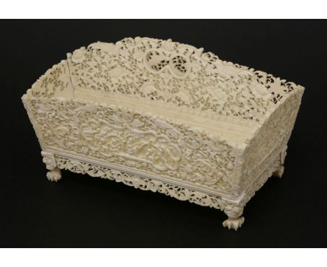 A Chinese Canton ivory desk stand,c.1880-1890, with two divisions, profusely carved with floral scrollwork and birds, each ce