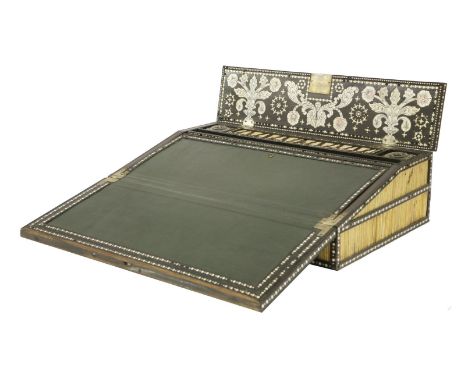 An Anglo-Indian ebony and ivory inlaid quill writing box,late 19th century, the hinged writing slope opening to reveal a repl