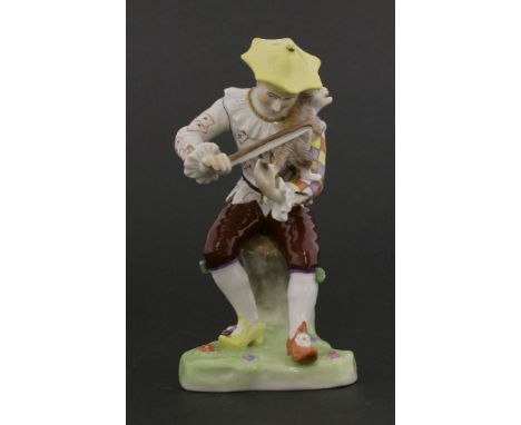 A Dresden figure,20th century, of a seated jester figure ‘playing a cat’, mounted on a triangular flower embellished base,15c