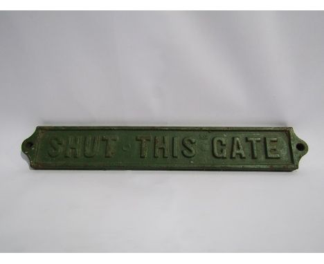 A cast iron SHUT THIS GATE sign