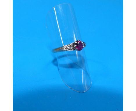 A dress ring stamped '22ct' set with a ruby coloured stone and a diamond to each side - 2.6gm