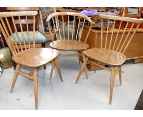 An Ercol stick back tub shaped armchair and 2 similar kitchen chairs