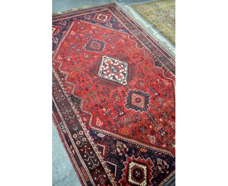 Red ground carpet of geometric design, 271cm x 174cm