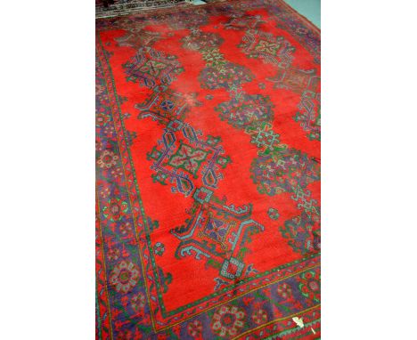 Large red ground turkish carpet, 337cm x 255cm, with two other rugs, each 194cm x 119cm and 151cm x 93cm 