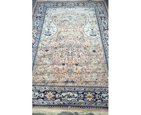 Persian pink and cream ground carpet, with main blue border and mulitple borders, decorated with foliate forms throughout, 27