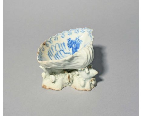 An early Bow blue and white salt, c.1750, of shell form, the scallop shell painted to the interior with tall rocks beside a w