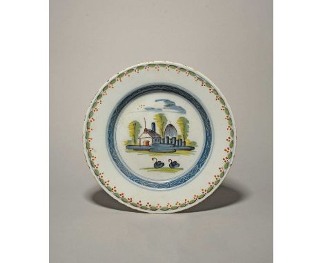 A delftware plate, c.1740, possibly Liverpool, painted in polychrome enamels with two swans swimming before low buildings and