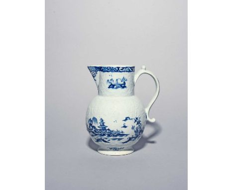 A large Lowestoft blue and white jug, c.1765, with floral moulding, painted with a Chinese figure beside plants and a three s