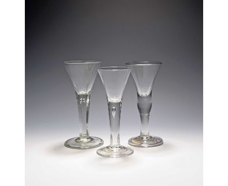 Three large wine glasses, c.1740-80, with drawn trumpet bowls, one on a plain stem with swollen knop over a folded foot, anot