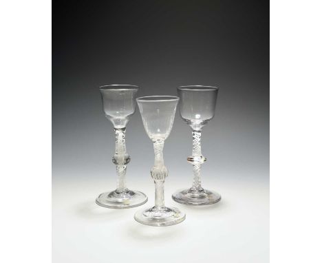 Three small wine glasses, c.1760, two with ogee bowls over multi-series opaque twist stems with central knops, the last with 