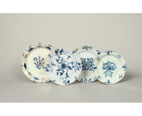 Four delftware plates, c.1720-50, of pancake shape, variously painted with central flower sprays of geometric swirls within f