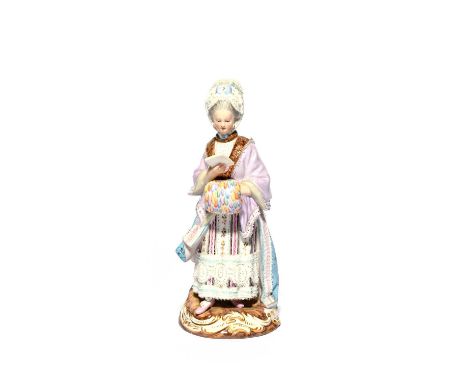 A Meissen figure of the Racegoer's Companion, 19th century, wearing a fur-lined lilac cloak over a striped floral dress, her 