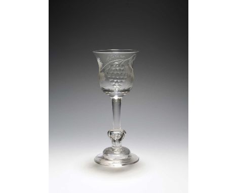 An unusual wine glass, c.1730, the tulip bowl engraved with a butterfly and a large bunch of polished grapes, raised on a pla