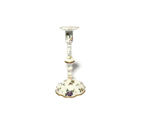 An English enamel candlestick, late 18th century, the hexafoil foot moulded and painted with flowers, with further single blo