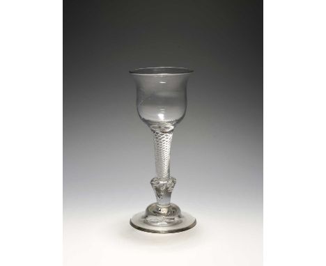 A composite stem wine glass, c.1730-40, with a tulip bowl raised on a composite stem including an airtwist section over an in