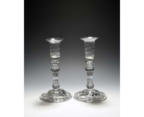 A rare pair of composite glass candlesticks, c.1760, English or Norwegian, the deep moulded sconces raised on beaded knops ov