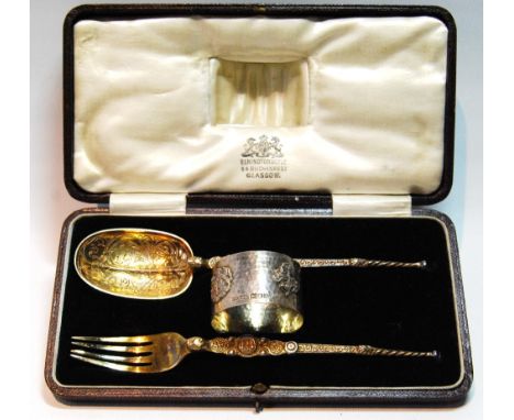 Silver parcel gilt christening set comprising a spoon and fork modelled after the Anointing Spoon and a napkin ring with the 