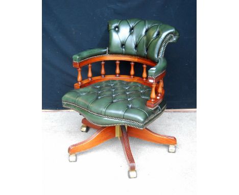 Victorian style button-back swivel chair, the faux green leather cushioned back and seat with baluster splats, raised on reed