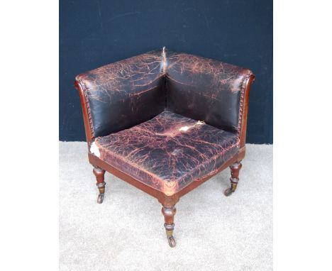 William IV mahogany and leather corner chair with loose cushion seat and raised on baluster turned legs, large brass caps and