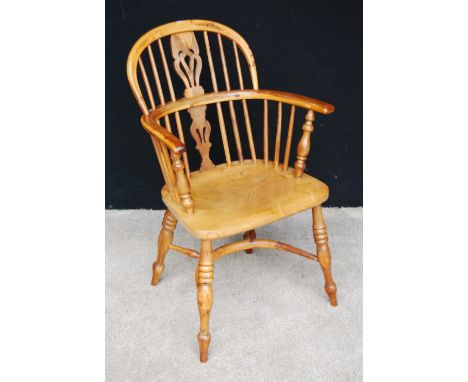 Yew wood Windsor chair with comb back, pierced central splat, hoop arms terminating in baluster columns, sloped seat, raised 