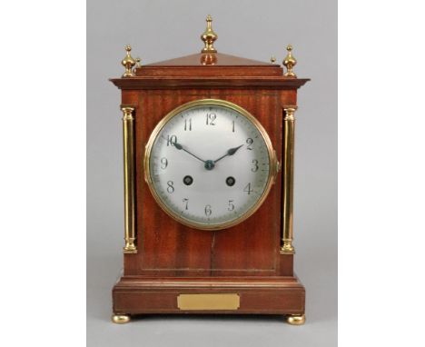 A Regency style mahogany brass strung and mounted mantel clock, circa 1900, with cylindrical pilasters, silvered dial, the tw