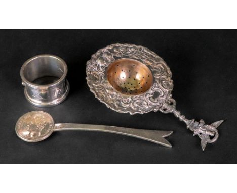 An ornate Italian silver tea strainer, with chick, flowerhead and leaf scroll embossed border, eagle and wreath handle, inscr