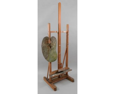 An artist's vintage adjustable easel, 55cm wide x 56cm deep, an artist's palette and a collection of brushes (qty).
