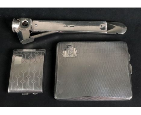 A silver mounted patent cigar cutter, London 1912, 16.2cm wide, initialled, an engine turned silver cigarette case and an eng