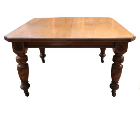 A late Victorian light oak extending dining table, the moulded rectangular top with two extra leaves, on ring turned, reeded 
