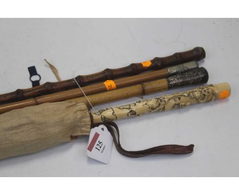 A late 19th century Chinese lady's parasol, the ivory handle carved with various emerging figures, having a plaited leather h