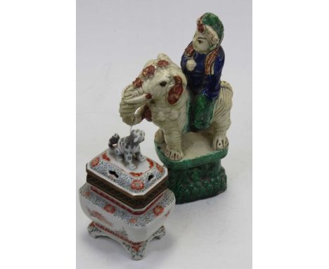 A 19th century Chinese ceramic figure of a dignitary riding on the back of an elephant, raised on plinth, glazed in shades of