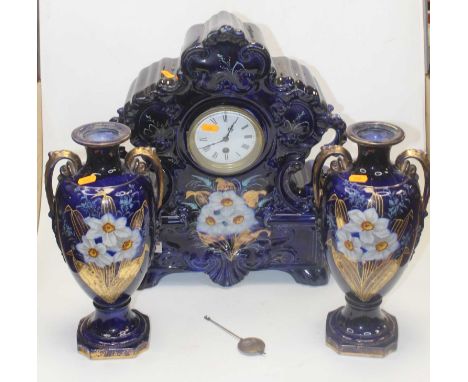 An early 20th century clock garniture, the central clock in blue ceramic surround with floral decoration having a circular en