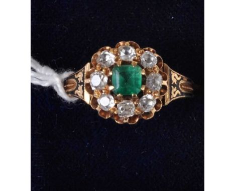 A Victorian yellow metal, emerald and diamond cluster ring, the centre round cut emerald within a surround of eight old cut d