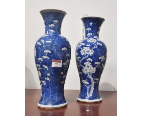 A pair of Chinese export vases, having a flared rim to a slender neck and baluster body, on a blue ground decorated with prun