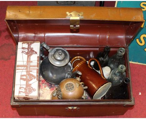 A tin trunk containing a collection of miscellaneous items to include a pewter teapot, glass bottles etc