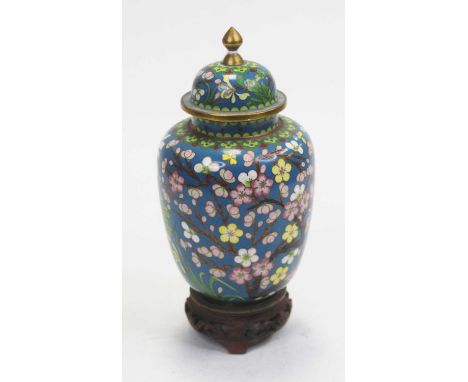 A 20th century Japanese cloisonné vase and cover, on a blue ground enamel decorated with pink and white flowers, raised on a 