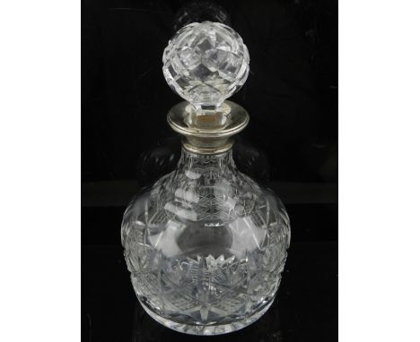 A silver topped cut glass decanter and stopper, Birmingham 1862, with cross hatched and palmette design. H. 23cm