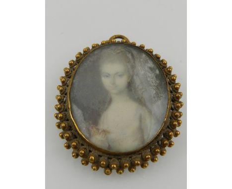 An early 19th century gilt metal mounted oval portrait miniature of a young bride. H. 4.5cm