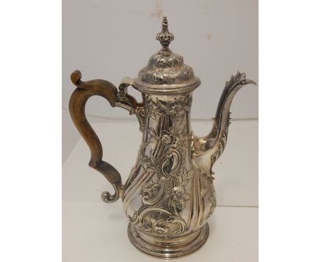 A George III silver baluster coffee pot, heavily embossed with flower heads and C scrolls, carved boxwood handle, maker F. M.