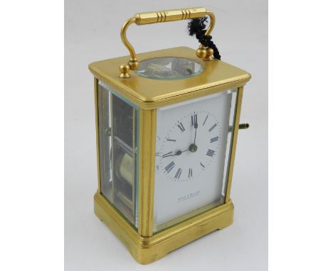 An early 20th century brass carriage clock, the enamel dial with Roman numerals and signed Kemp & Wilcox, Wolverhampton, two 