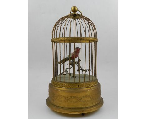 In the style of Bontems, an early 19th century French automaton musical bird cage, having feather bird within a gilded cage, 