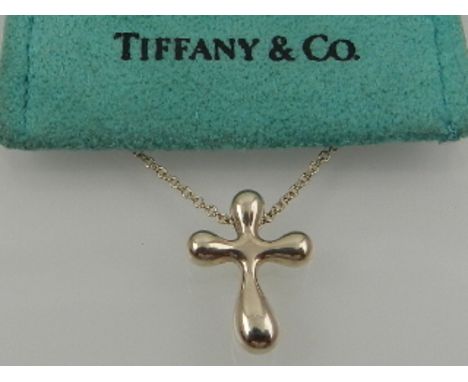 Tiffany & Co. New York. A silver cross pendant, suspended on a silver chain, boxed. 
