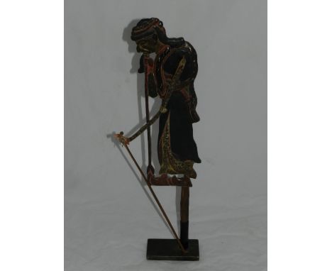 A Persian painted wooden and metal shadow puppet, mounted on display base. H: 55cm