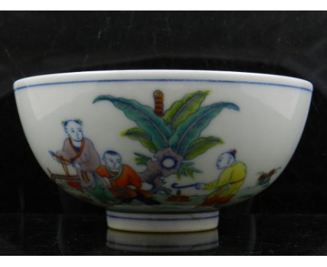 A Chinese doucai rice bowl, decorated with a continuous scene of children playing in garden landscape, bears six character ma