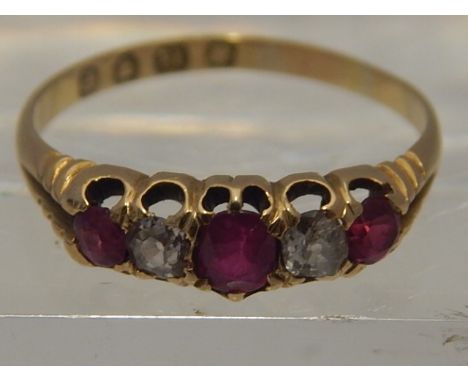 An 18 carat yellow gold, diamond, and ruby five stone ring, set three graduated round cut rubies and two round cut diamonds. 