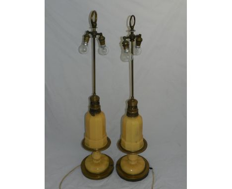 A pair of brass twin-light table lamps, having mustard yellow ceramic bases, converted from oil lamps. H: 93cm